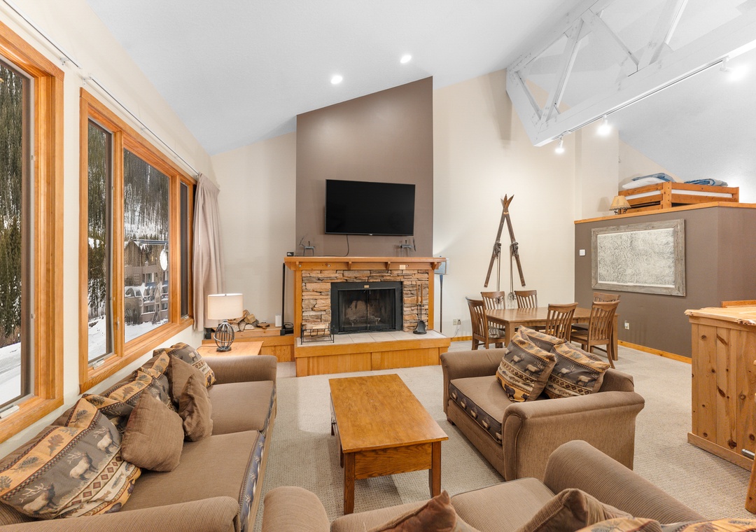 Cozy up by your crackling stone fireplace while snow falls outside your windows, with comfortable seating and mountain charm throughout.