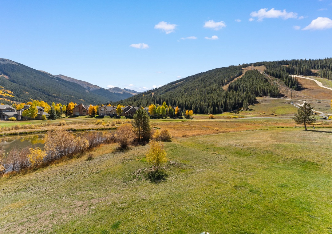Mountain valley setting with ski slopes, autumn foliage, and forested peaks creating a scenic alpine backdrop.