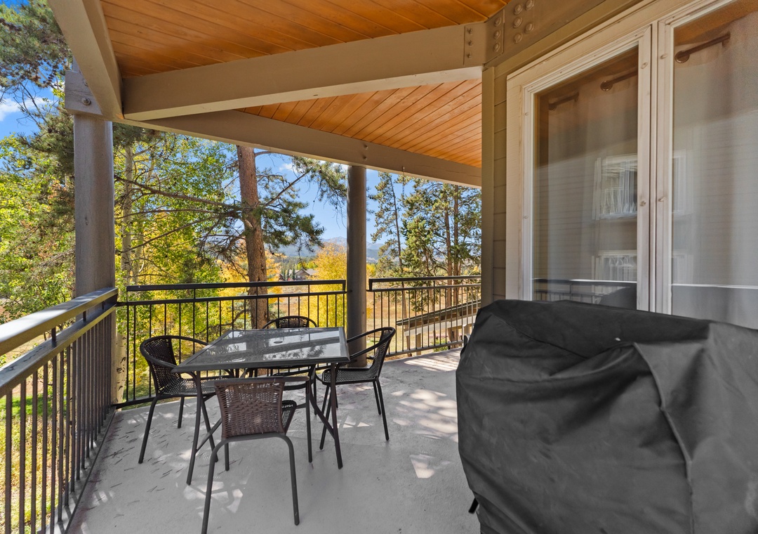 Unwind on your private covered balcony with outdoor dining and BBQ, overlooking beautiful autumn trees and natural landscape.