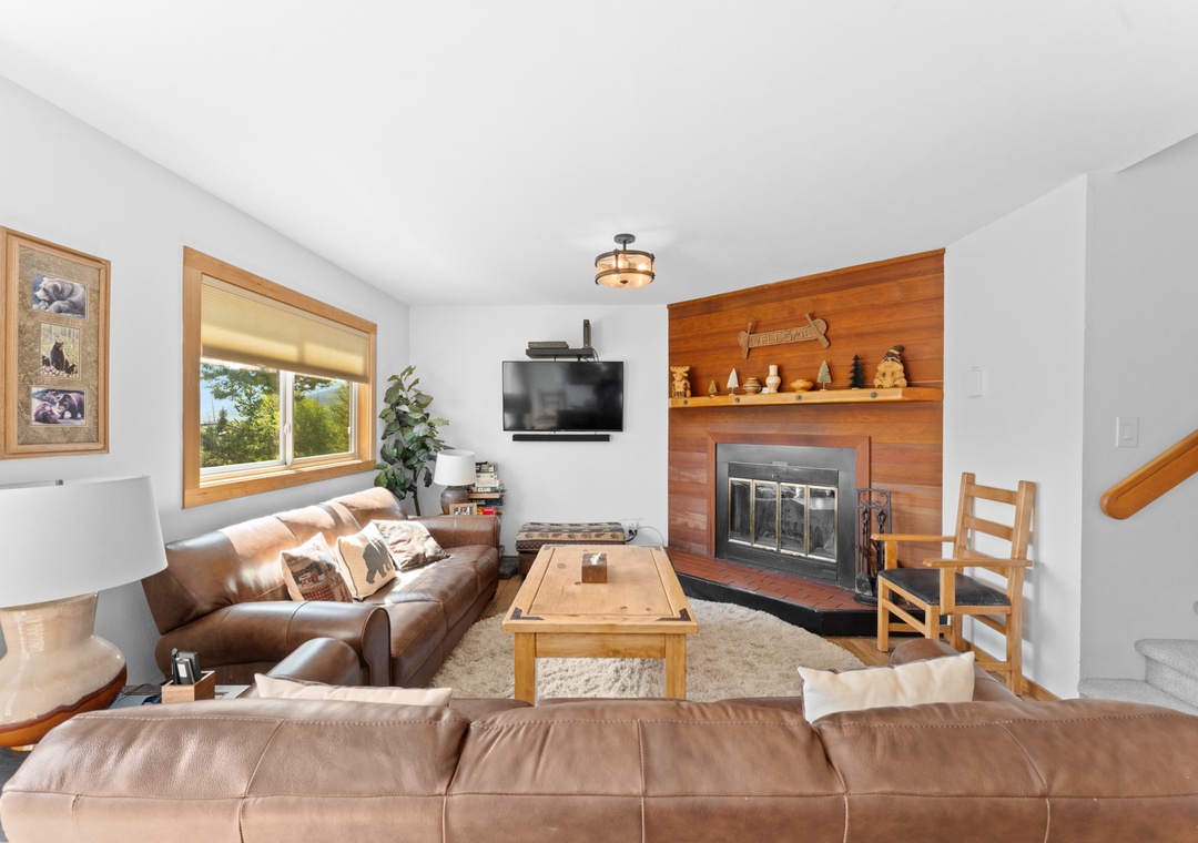 Cozy up in your warm living room with leather seating, crackling fireplace, and rustic wood accents for perfect mountain evenings.