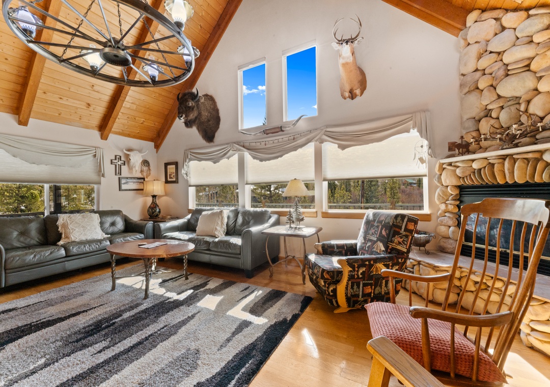 Relax in your charming mountain retreat with vaulted ceilings, cozy stone fireplace, and panoramic windows framing nature views.
