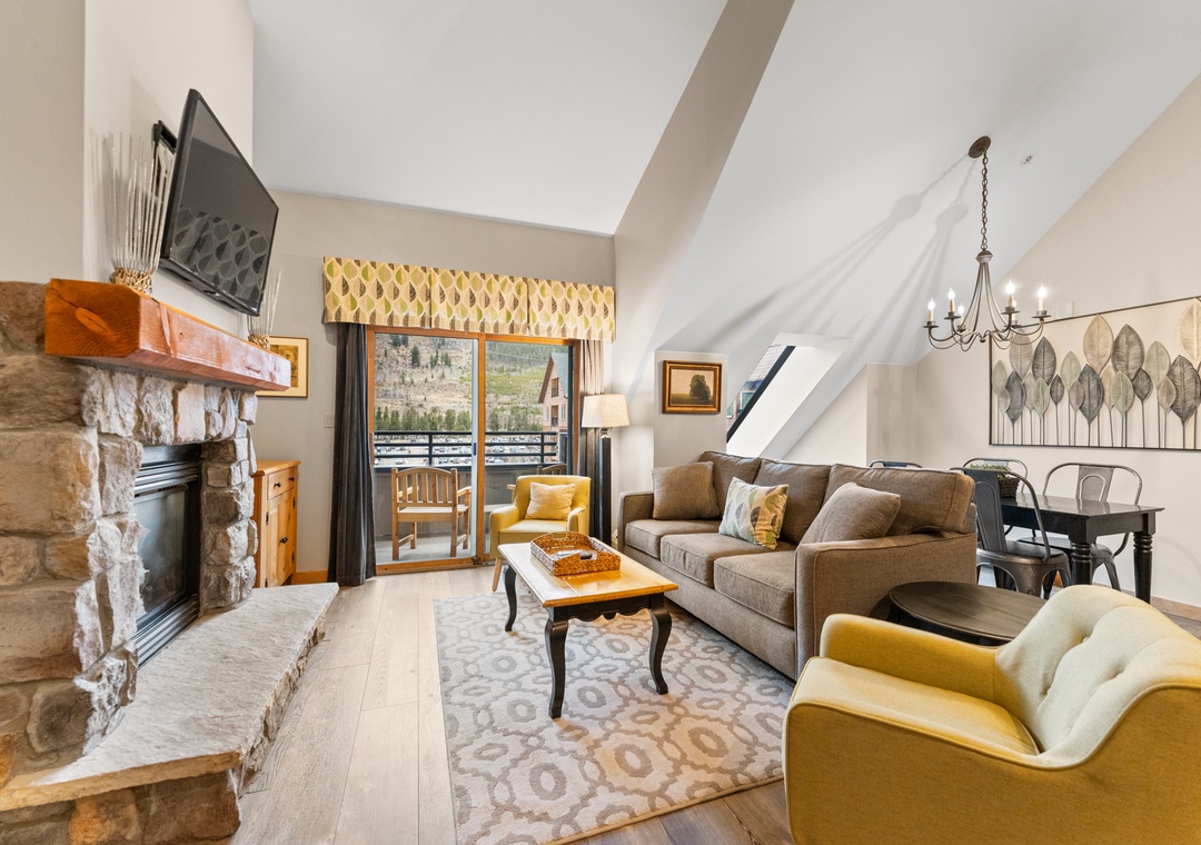 Relax in your inviting living space with a crackling fireplace, cozy seating, and mountain views from your private balcony.