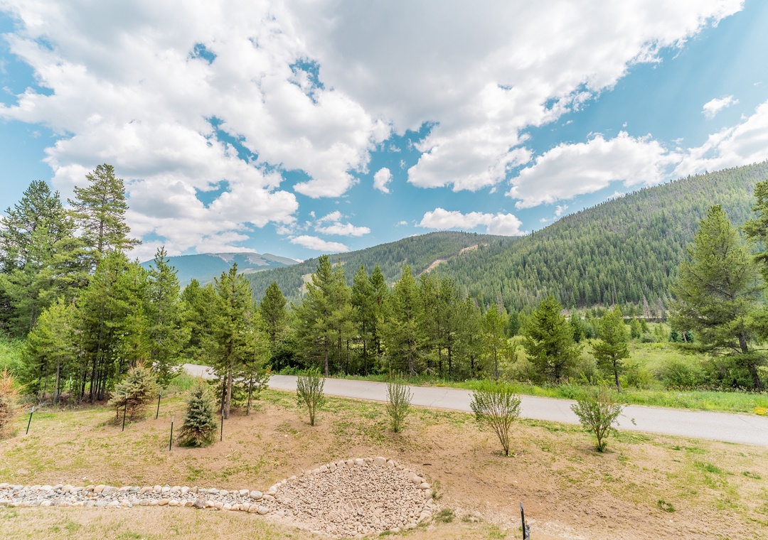 Stunning mountain landscape with rolling forested hills and peaceful countryside roads creating a serene natural setting.