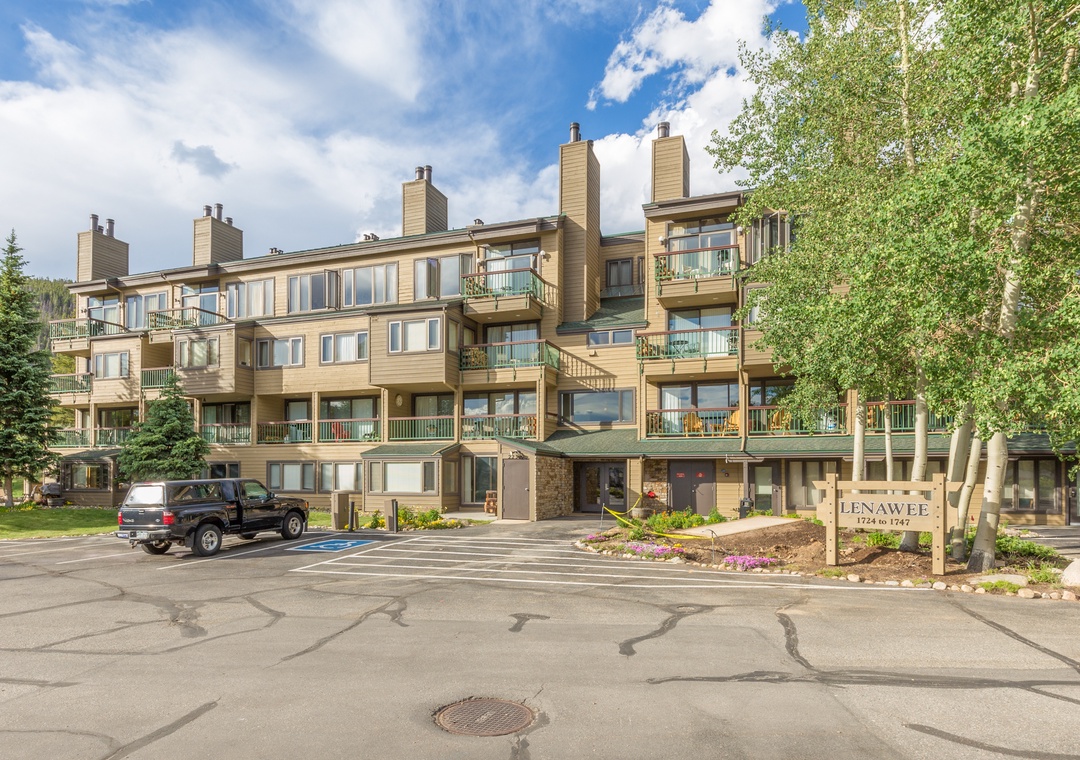 The Lenawee building entrance welcomes arrivals with landscaped grounds and convenient parking in a peaceful residential setting.