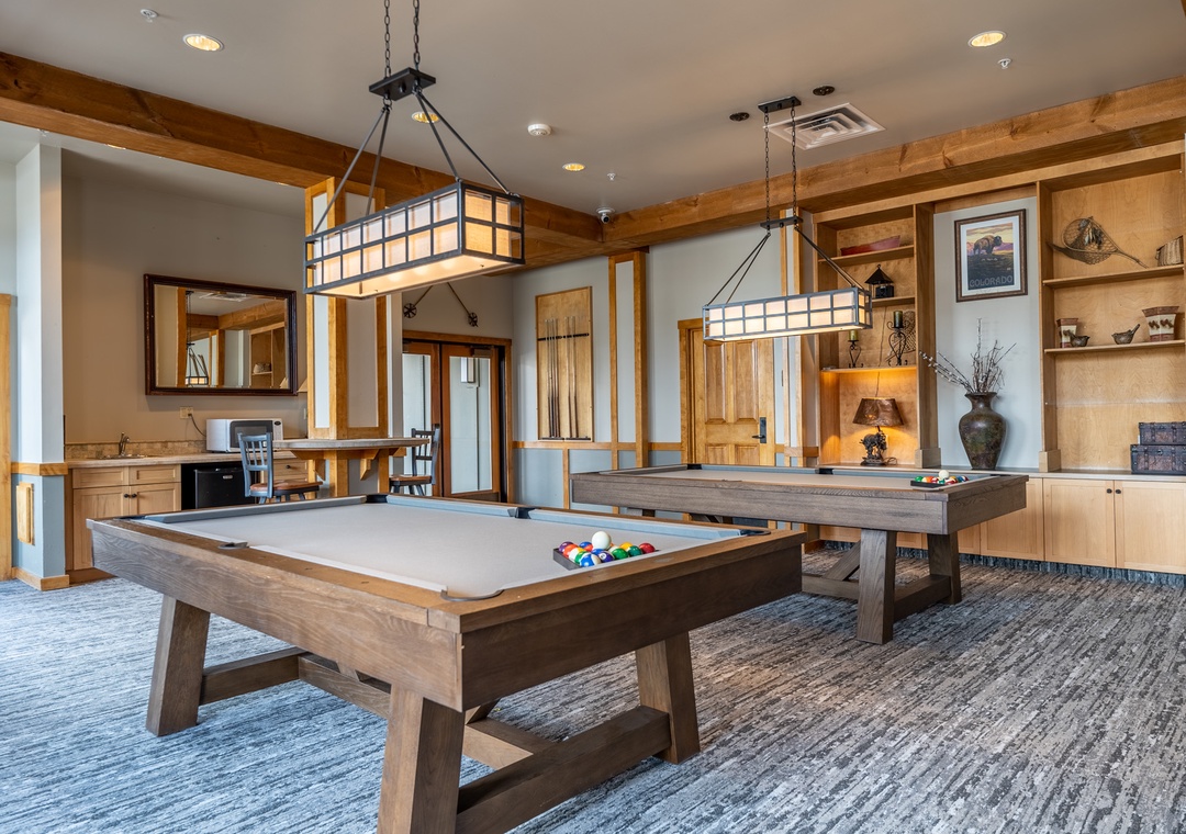 Challenge friends to pool games in this elegant billiards room, where warm wood tones and pendant lighting create the perfect atmosphere for relaxation.