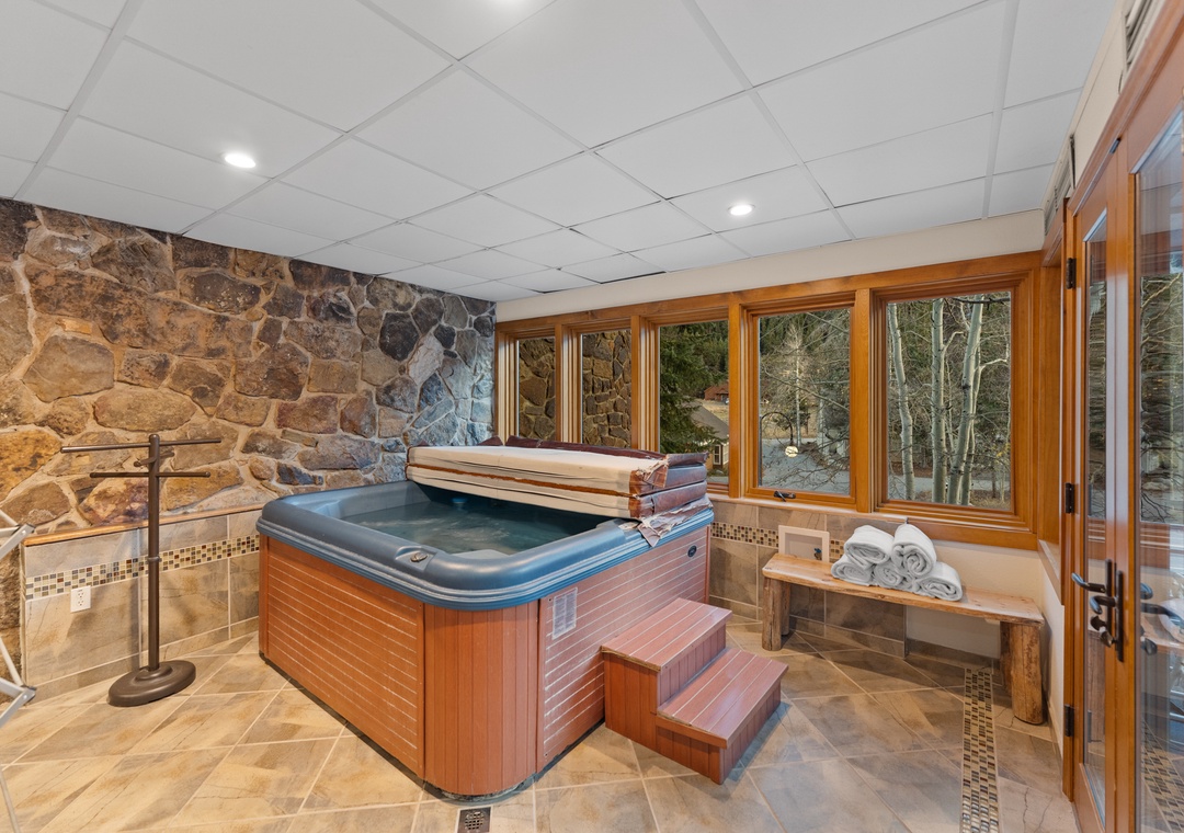 Soak your cares away in this private hot tub sanctuary, surrounded by stunning stone walls and forest views.