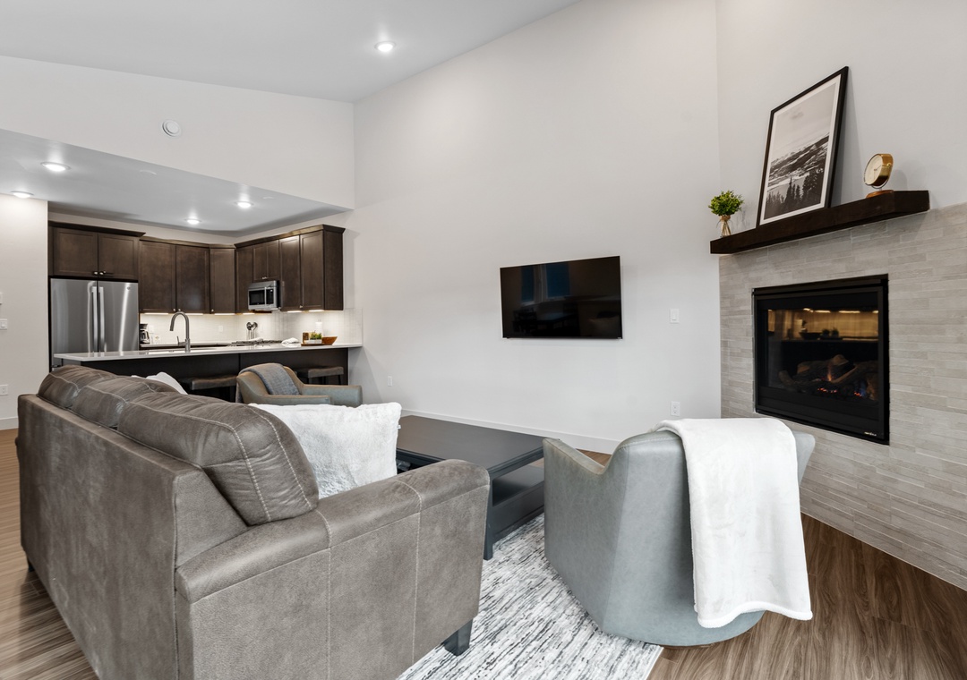 Unwind in your sophisticated living space where modern comfort meets elegant design, complete with cozy fireplace and open kitchen.