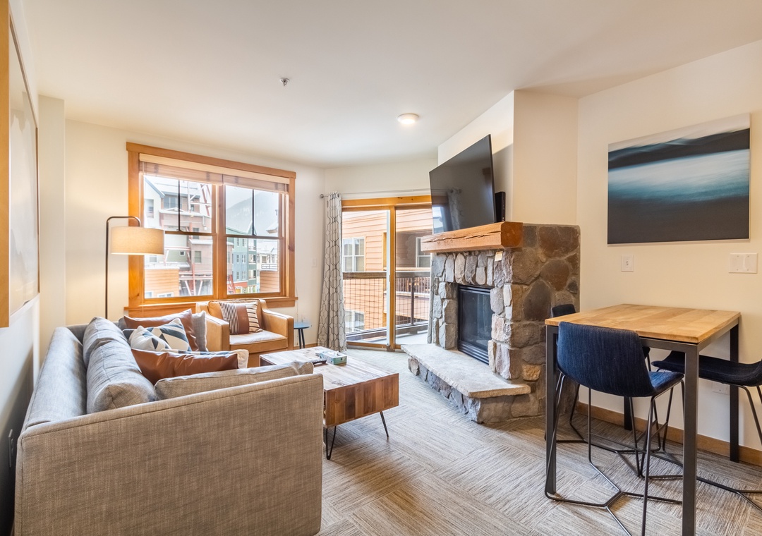 Unwind in your cozy living room with plush seating, warm fireplace, and modern amenities perfectly designed for mountain relaxation.