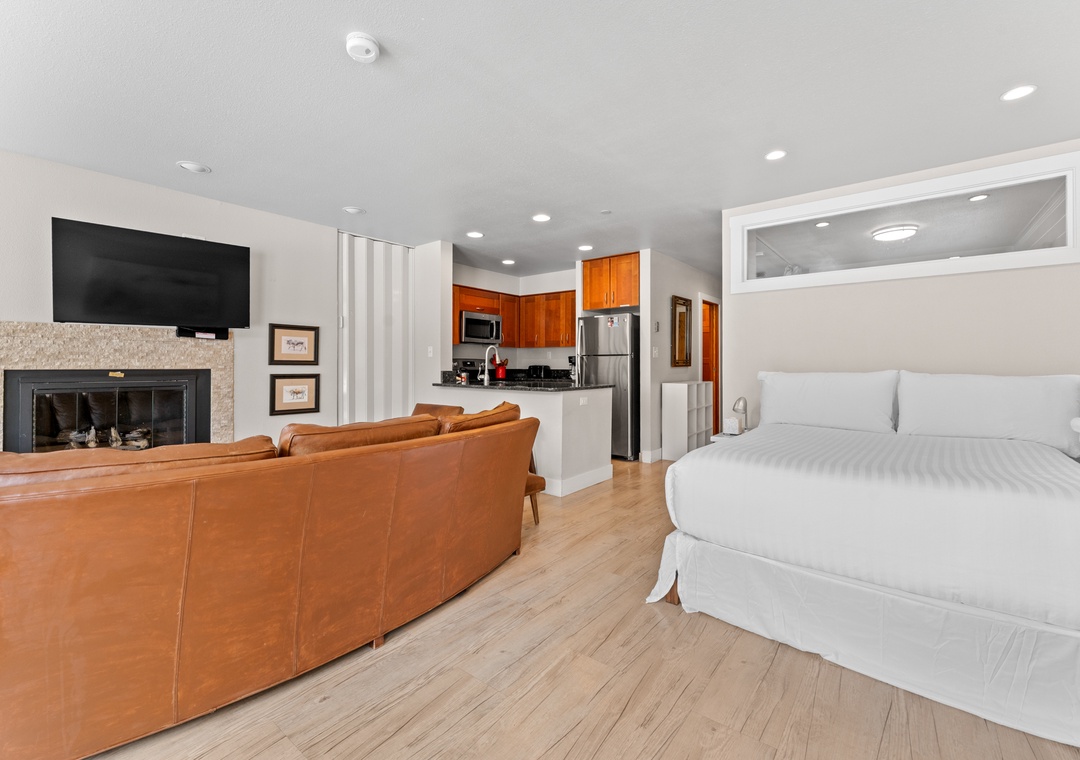 Unwind in your stylish studio featuring a cozy fireplace, leather seating, and fully equipped kitchen—perfect for relaxing after exploring.