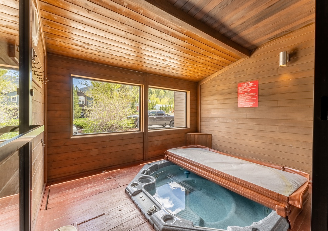 Sink into warm bubbling waters in your private wooden hot tub sanctuary, where floor-to-ceiling windows frame peaceful views.