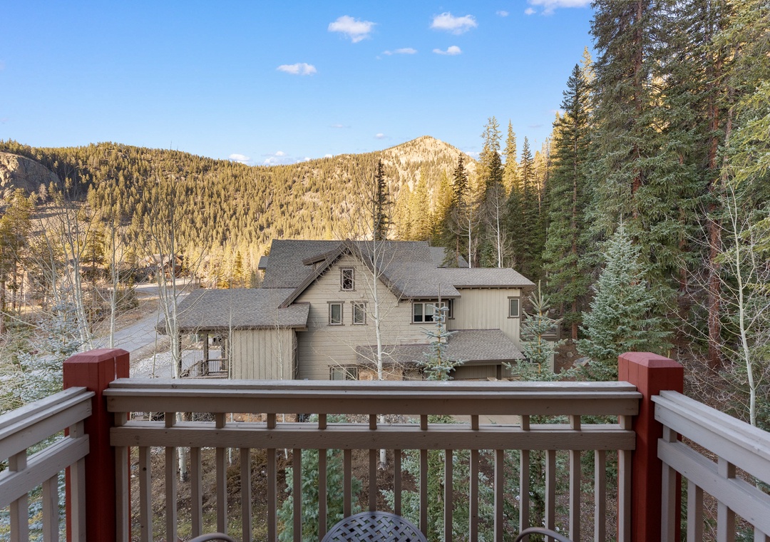 Mountain views frame this peaceful alpine retreat, surrounded by towering evergreens and dramatic peaks that define the scenic landscape.
