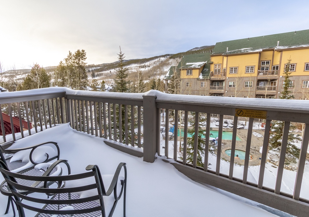 Step onto your private balcony and breathe in crisp mountain air while enjoying stunning views of snow-covered peaks and the inviting pool below.