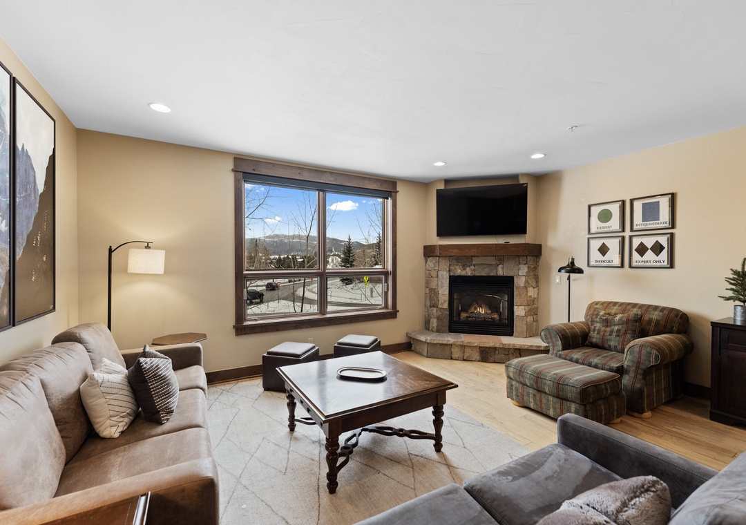 Unwind in your spacious living room with a crackling fireplace, mountain views, and cozy seating perfect for après-ski relaxation.