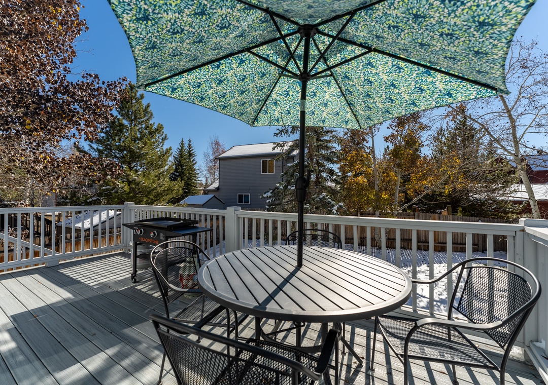 Step onto your private deck where morning coffee tastes better under the shaded umbrella, surrounded by peaceful neighborhood views.