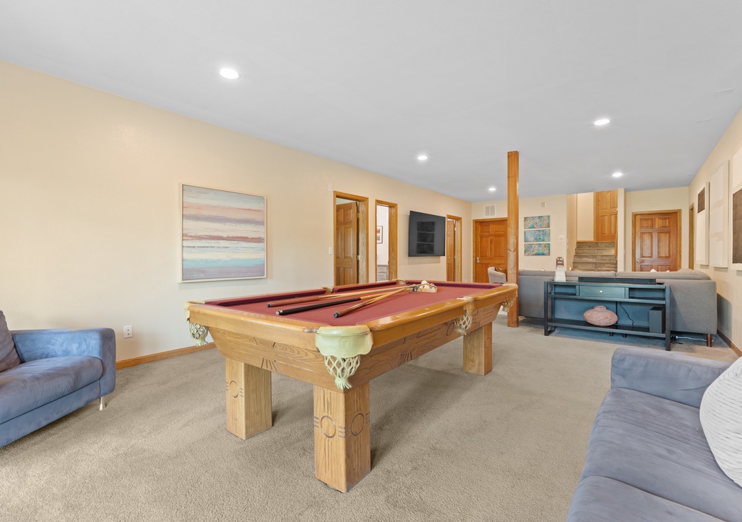 Challenge your group to a friendly game in this inviting rec room, complete with a classic pool table, plush seating, and warm lighting for hours of fun.
