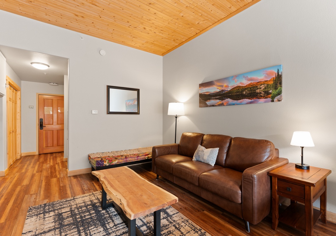 Unwind in this cozy living space, where warm wood tones and soft lighting invite you to settle in after a day of adventure. Kick back on the leather sofa and feel right at home.