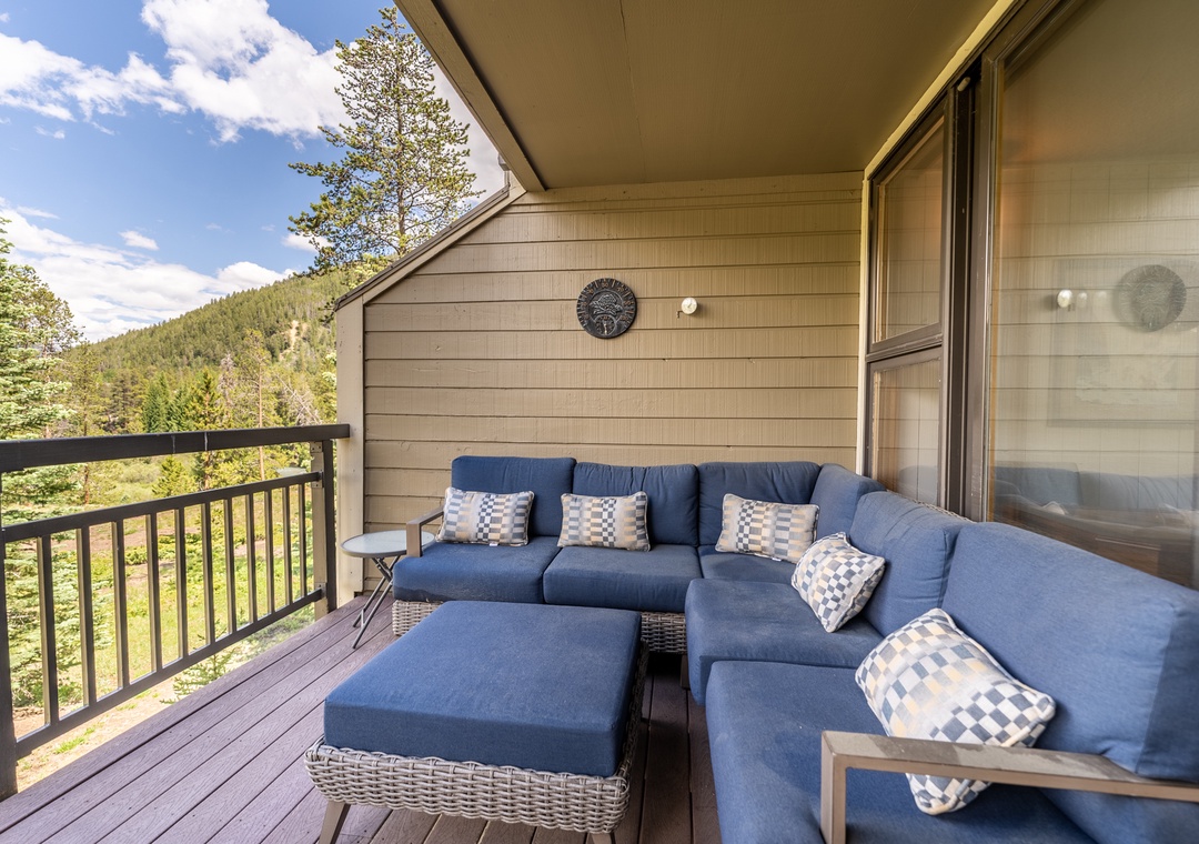 Sink into plush blue cushions on your private balcony and breathe in mountain air while forest views stretch endlessly before you.