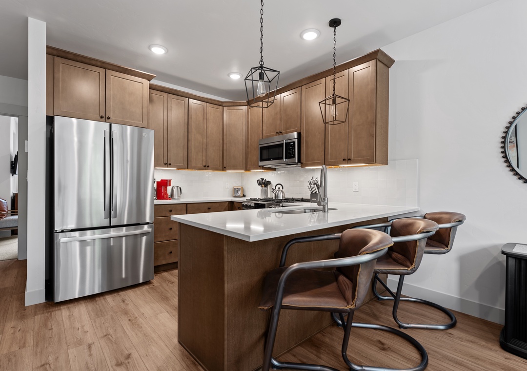 Settle in at your spacious kitchen island, where warm wood cabinetry and modern appliances create the perfect setting for morning coffee or casual meals with your crew.