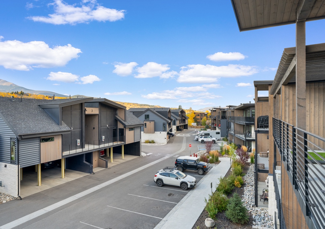 Modern residential complex with mountain views and convenient parking, featuring contemporary architecture and landscaped grounds.