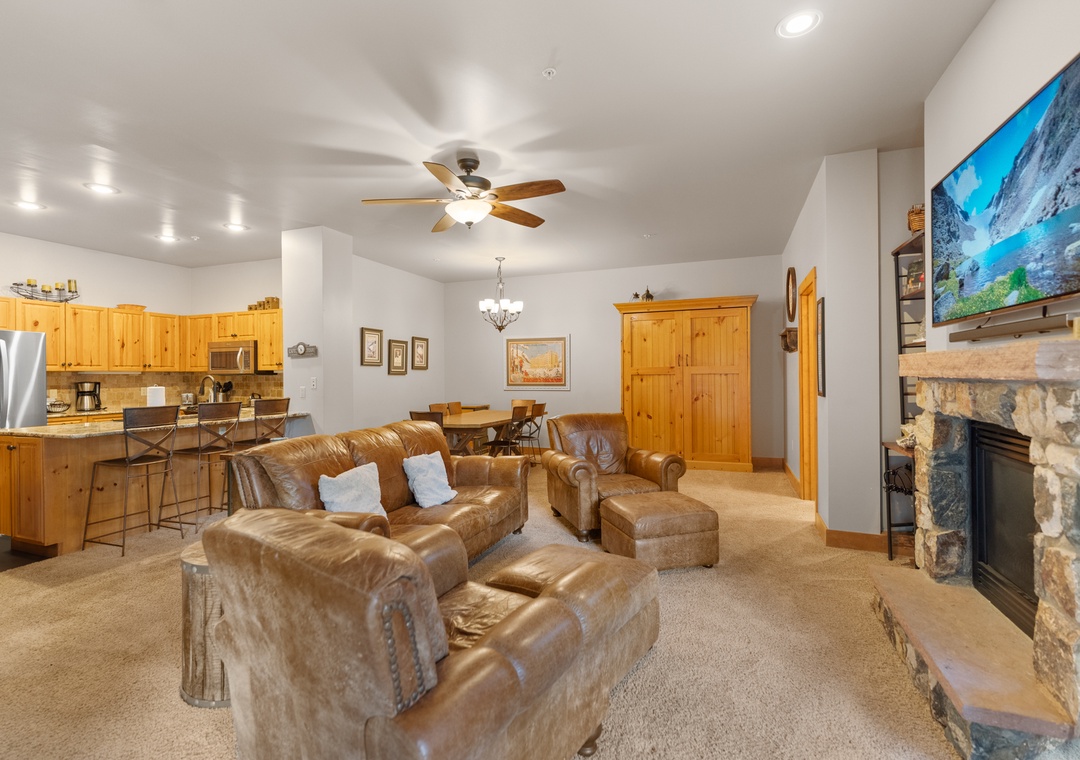 Unwind in your spacious living room with plush leather seating, warm fireplace, and open kitchen—perfect for memorable evenings together.