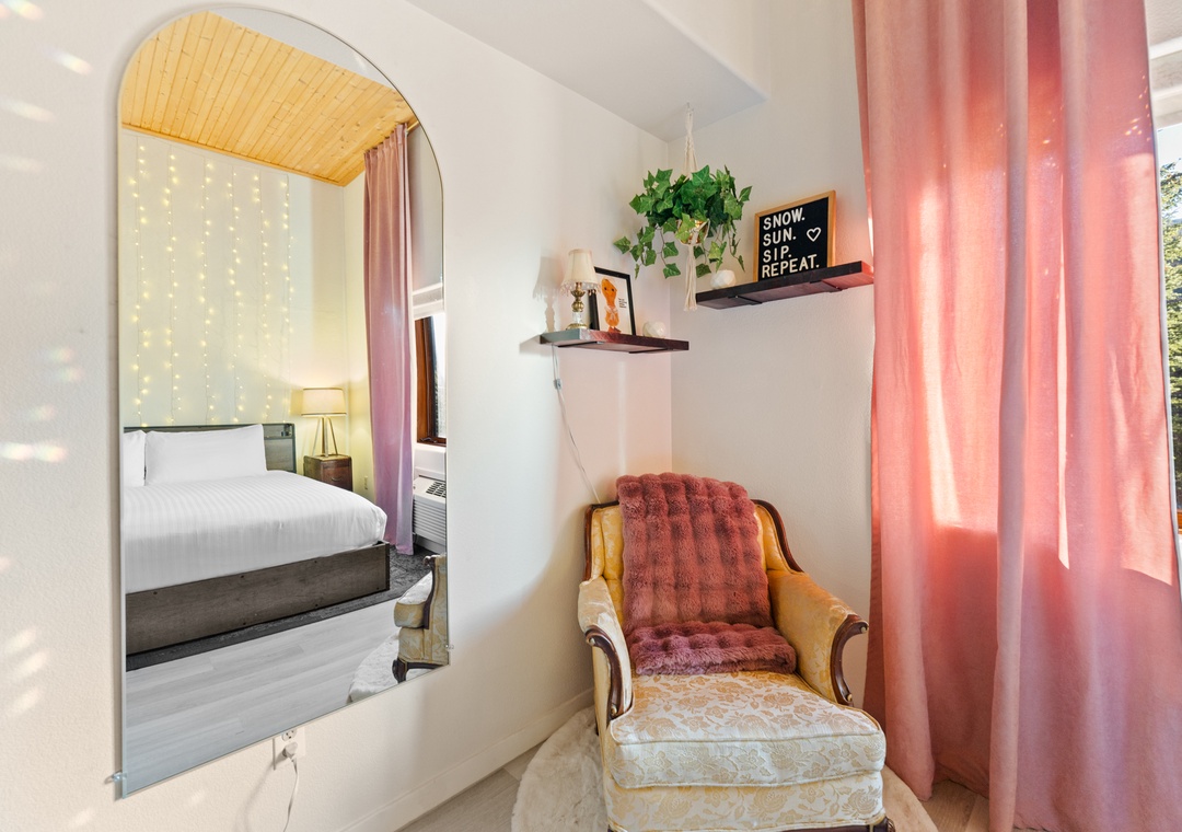 Sink into your cozy reading chair and watch fairy lights twinkle through the mirror, creating magical reflections in your peaceful retreat.