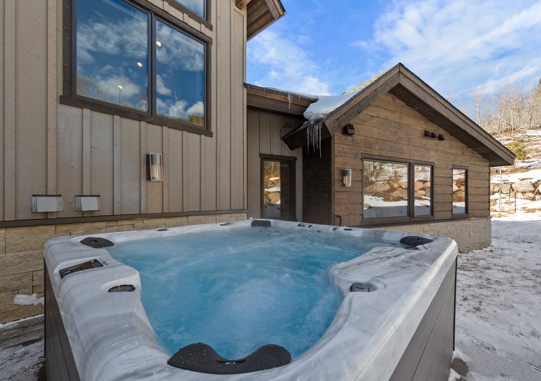 Soak in your private hot tub surrounded by pristine winter scenery and mountain views at this stunning alpine retreat.