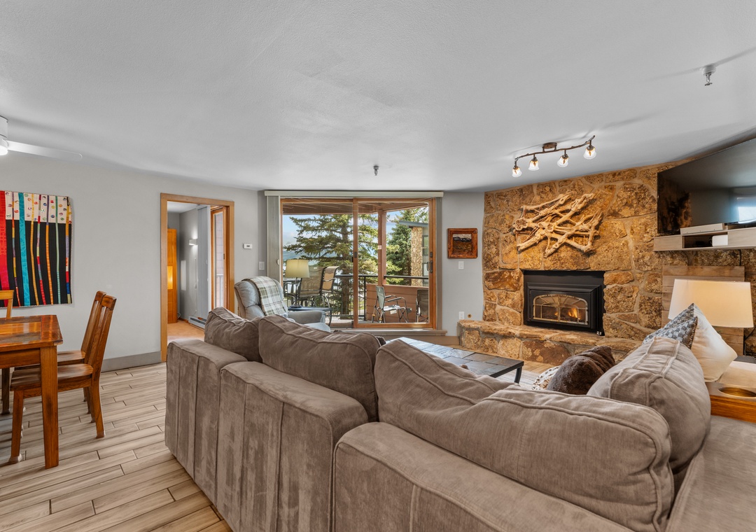 Sink into plush sofas by the stone fireplace, where warmth and mountain views create your perfect retreat after a day of adventure.