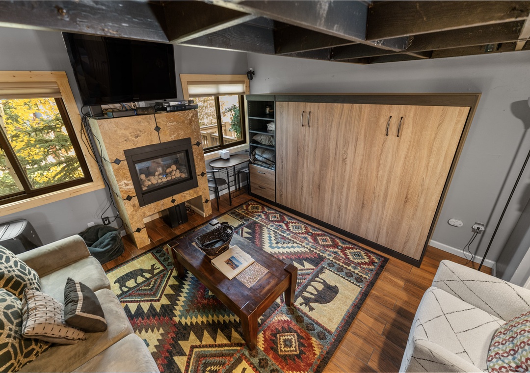 Unwind in your cozy living space featuring a warm fireplace, comfortable seating, and modern amenities for the perfect mountain retreat experience.