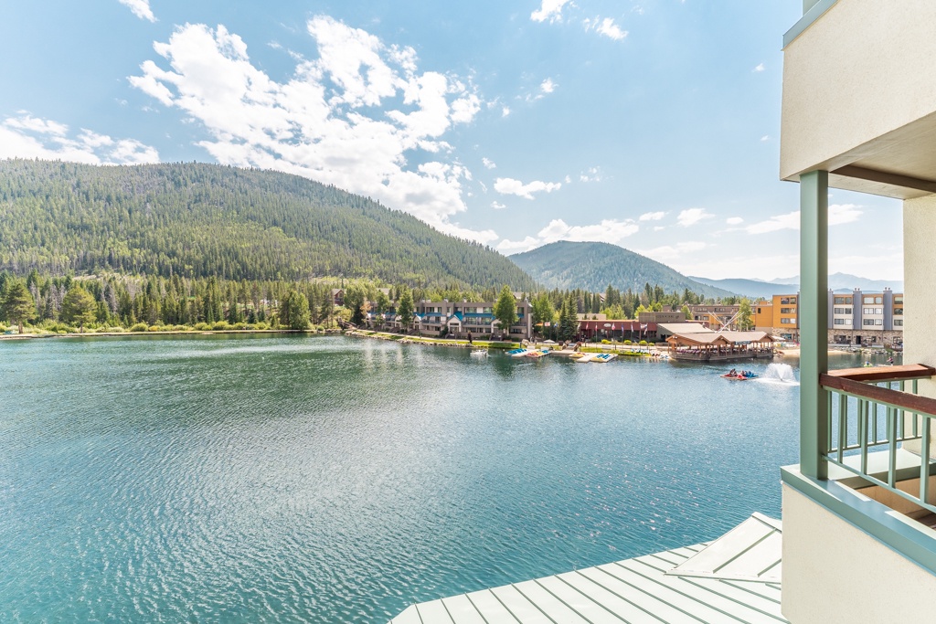 Stunning lakefront view with forested mountains and charming waterfront village creating a peaceful alpine setting.