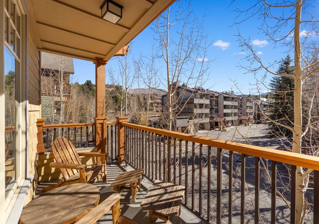Relax on your private balcony with wooden chairs, enjoying mountain views and fresh air in this peaceful retreat.