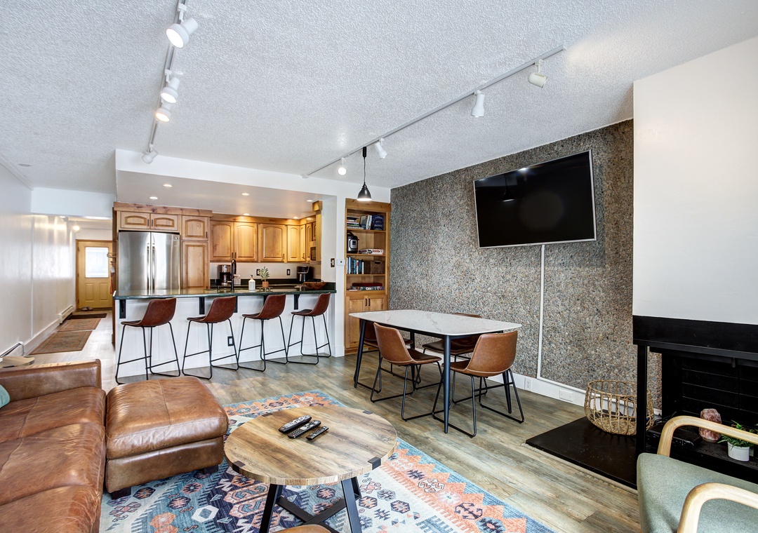 Your open-concept living space seamlessly blends comfort and style with rich leather seating, modern kitchen, and cozy fireplace.