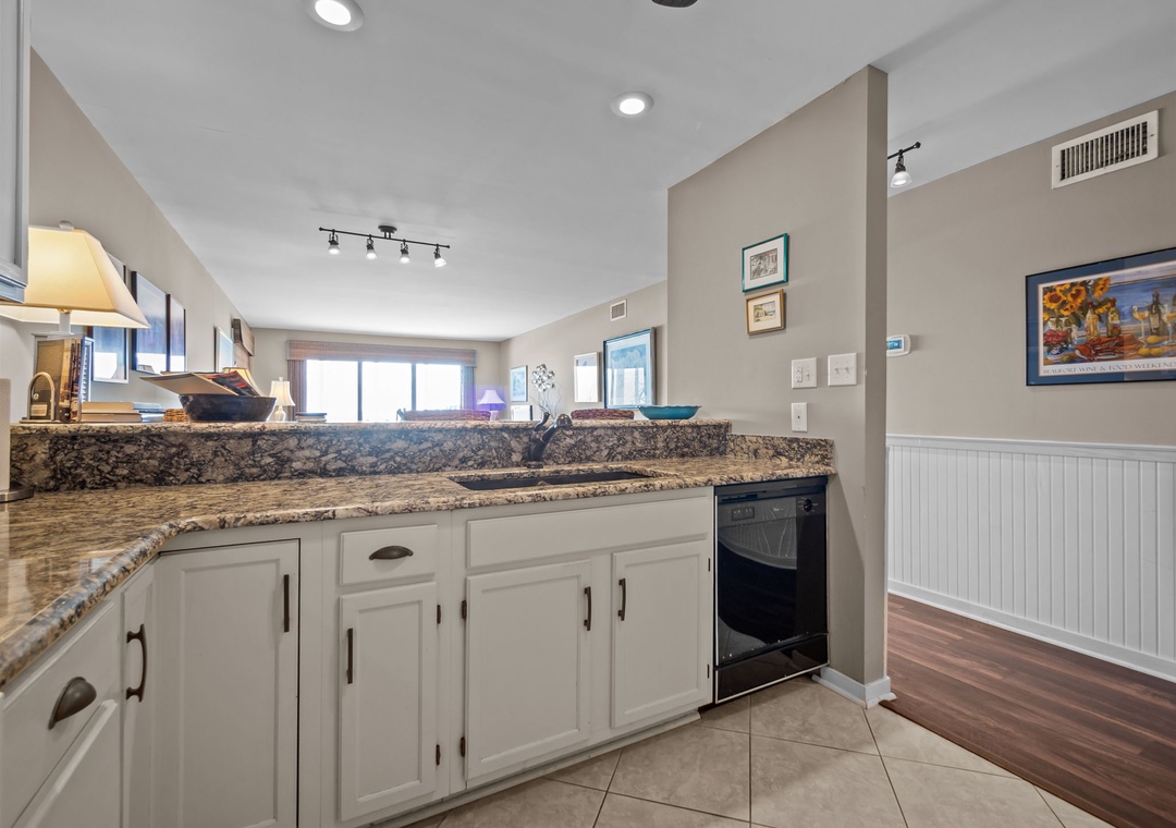 Prepare your favorite meals in this spacious kitchen featuring granite countertops, white cabinetry, and modern appliances that make cooking a pleasure.