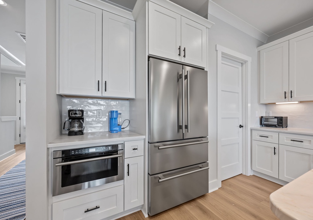 Your modern kitchen features sleek white cabinetry, stainless steel appliances, and thoughtful touches like built-in coffee stations for perfect morning routines.