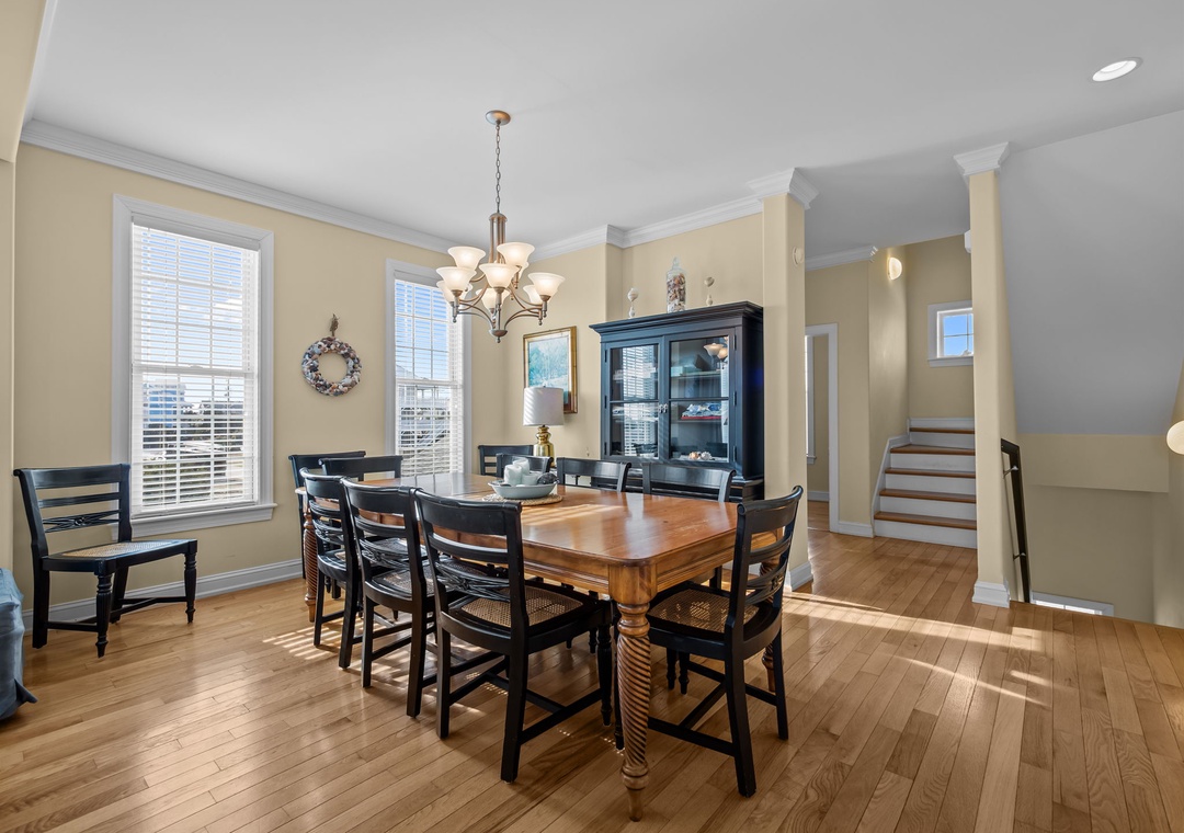 Gather around your elegant dining table where natural light streams through large windows, creating the perfect setting for memorable meals together.