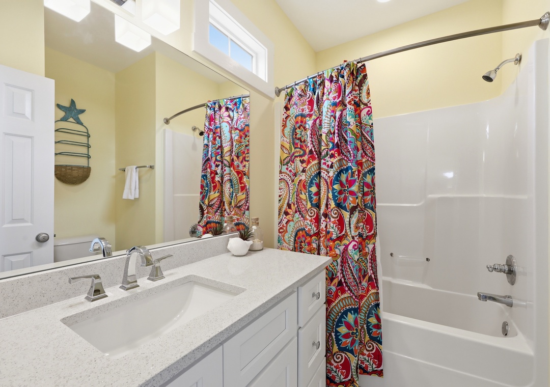 Refresh in your cheerful bathroom with dual sinks, a soaking tub, and lively coastal charm—perfect for starting and ending your day in comfort.