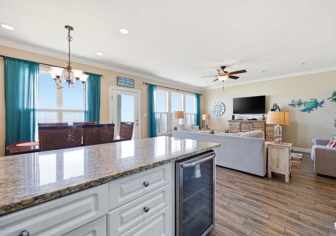 Bright coastal-inspired space with stunning ocean views through expansive windows. The open layout blends living and kitchen areas, offering easy entertaining and comfortable relaxation.