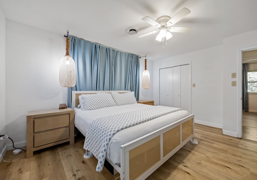 Unwind in your serene coastal-inspired bedroom with crisp linens, gentle ceiling fan breeze, and charming pendant lights.
