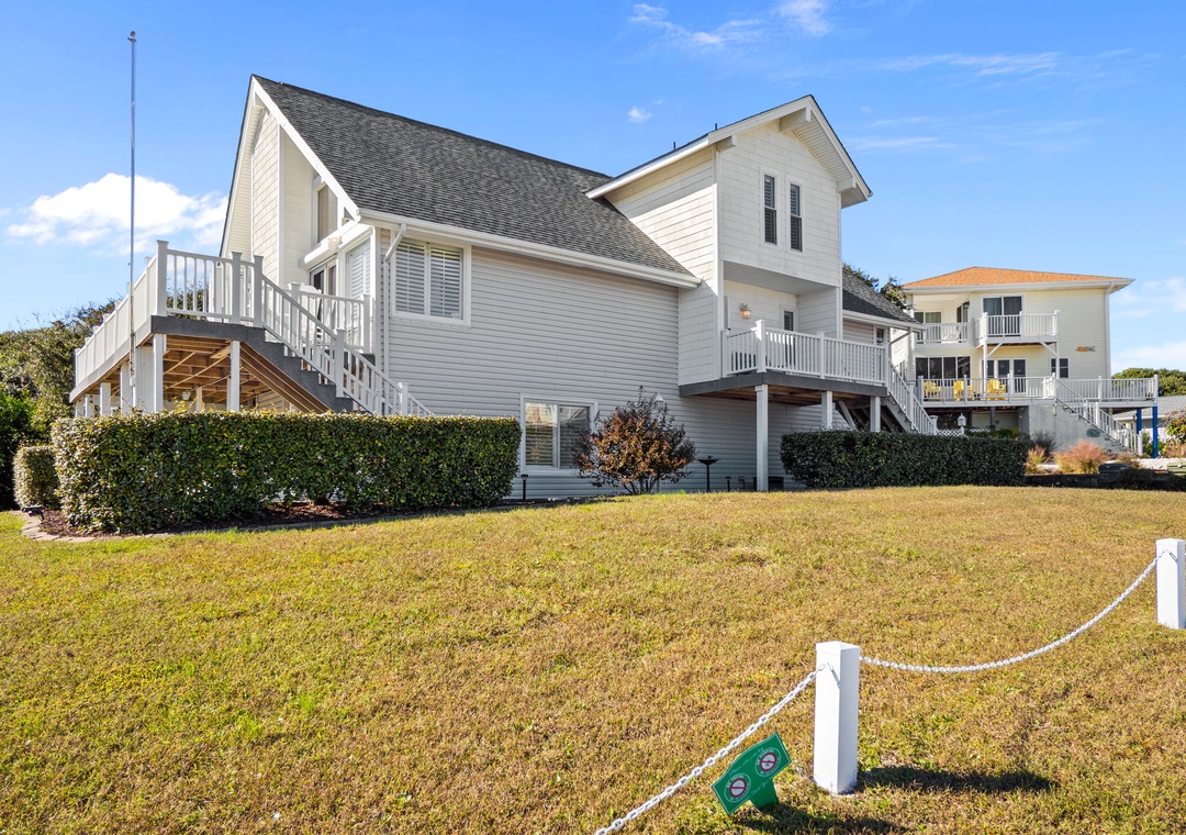 Charming elevated beach house with wraparound decks and coastal architecture nestled in a peaceful residential neighborhood.