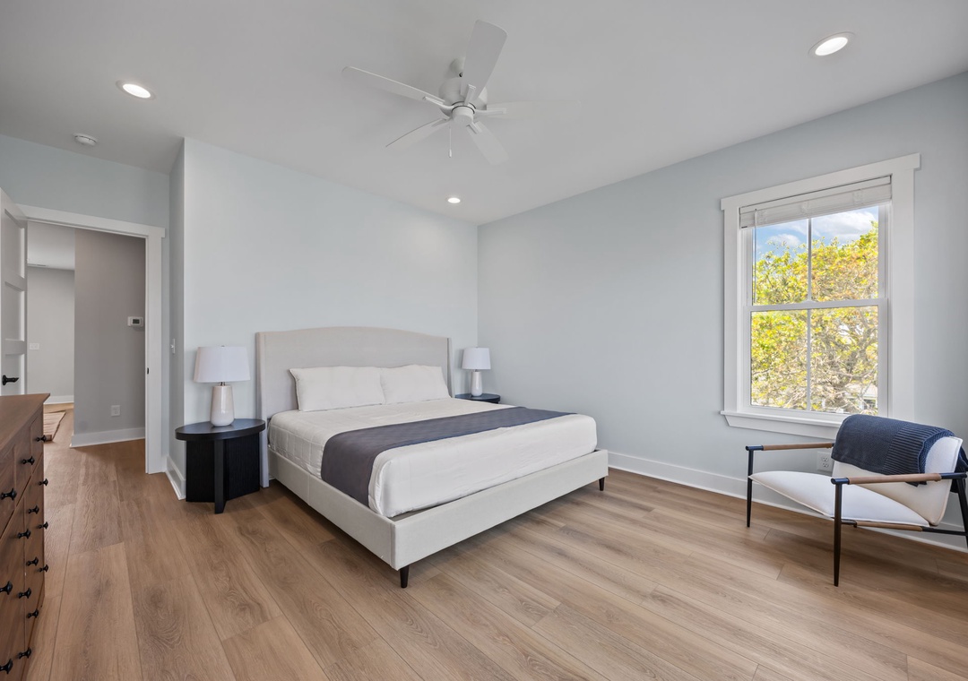 Rest peacefully in your serene bedroom featuring a comfortable bed, modern furnishings, and natural light streaming through large windows.