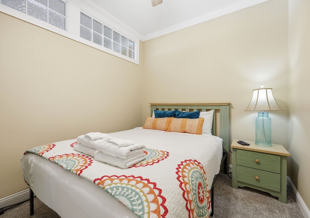 Rest easy in this cozy bedroom with crisp linens, colorful accents, and soft lighting—your peaceful retreat after a day of adventure.