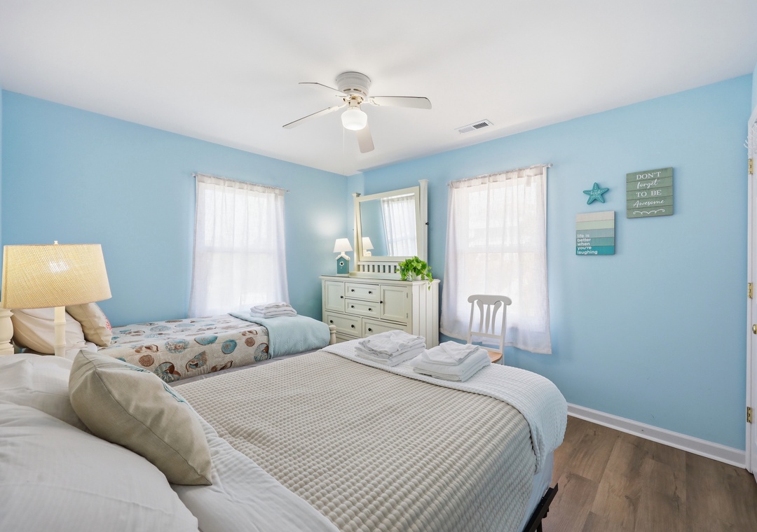 Step into your serene coastal retreat with soft blue walls, comfortable beds dressed in crisp linens, and nautical accents that invite peaceful relaxation after a day of adventure.