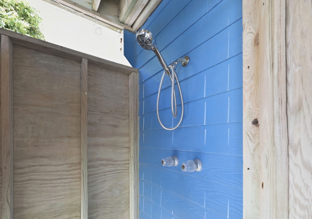 Rinse away the day in your private outdoor shower, complete with a rainfall head and cheerful blue tile that captures the coastal vibe.