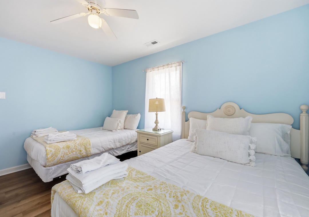Rest easy in this serene coastal bedroom with plush beds dressed in crisp linens and soft throws, where gentle sea breezes and natural light welcome you home.