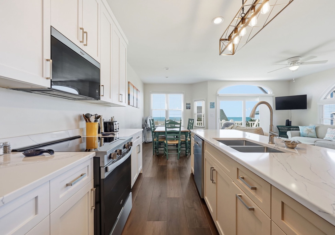 Cook your favorite meals in this bright, fully-equipped kitchen with modern appliances and gorgeous ocean views that extend seamlessly into the dining and living areas.