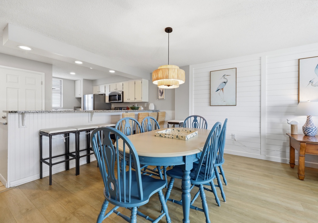 Gather around the charming coastal dining table with seating for six, perfectly positioned between your fully equipped kitchen and bright, beach-inspired living space for effortless entertaining.