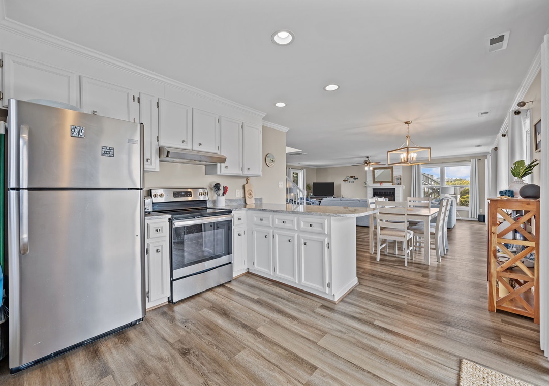 Your spacious kitchen features gleaming stainless steel appliances, crisp white cabinetry, and a generous island perfect for cooking meals together.