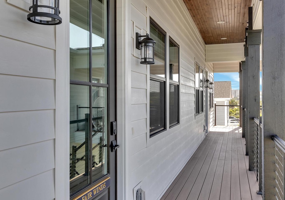 Step onto this welcoming covered deck with warm wood ceilings and ambient lanterns lighting your way to the front door.