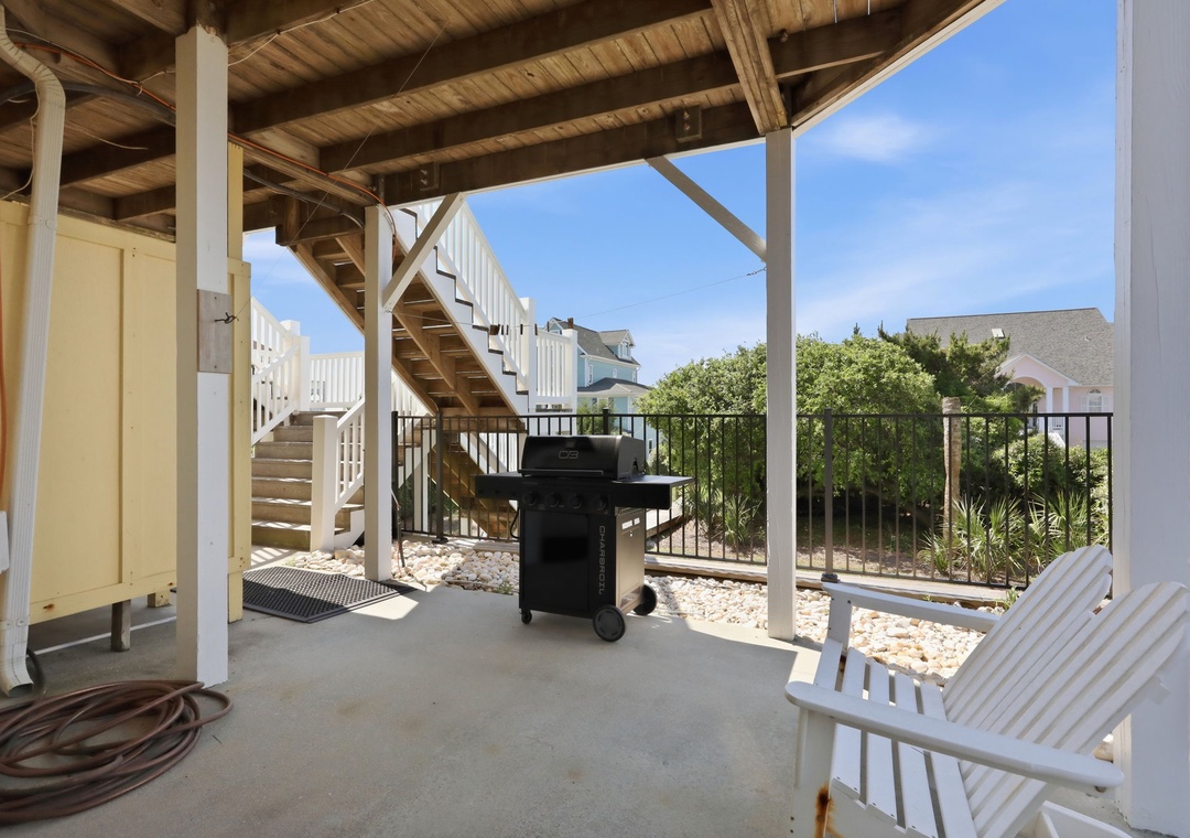 Your private covered patio features a BBQ grill and lounge seating where you can relax, surrounded by coastal greenery and blue sky.