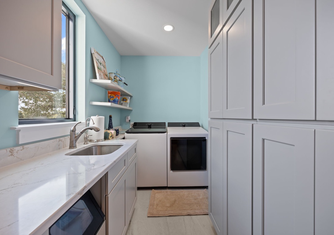 Your bright, modern kitchen features sleek cabinets, quartz counters, and everything needed for home-cooked meals during your stay.