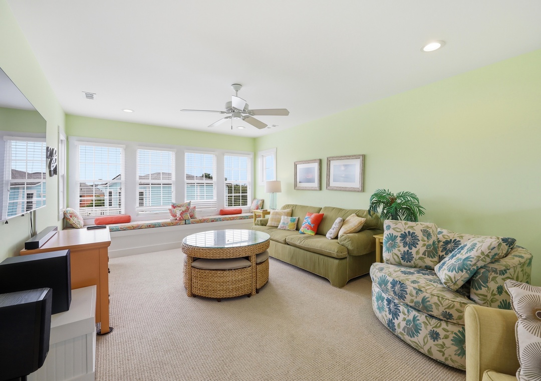 Kick back in this cheerful living room where soft green walls, comfy seating, and a window seat overlooking the water invite you to relax and unwind.